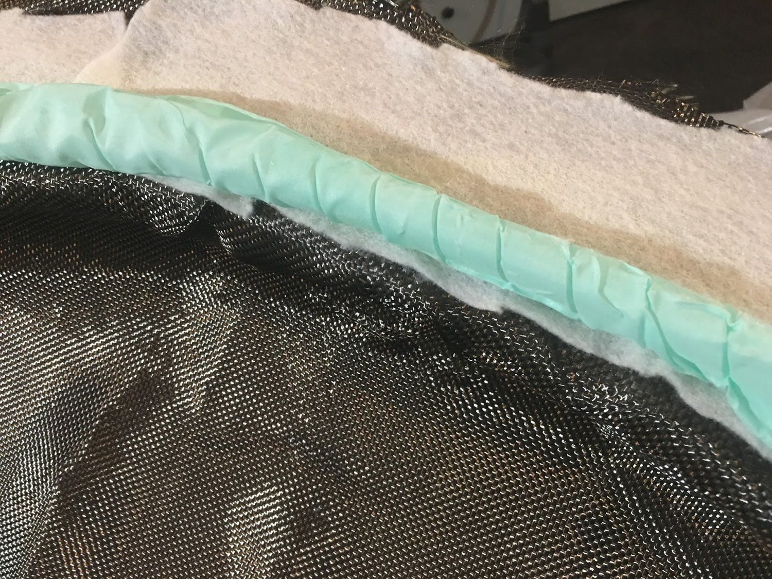 Nylon-wrapped spiral tubing (green) on mold lip