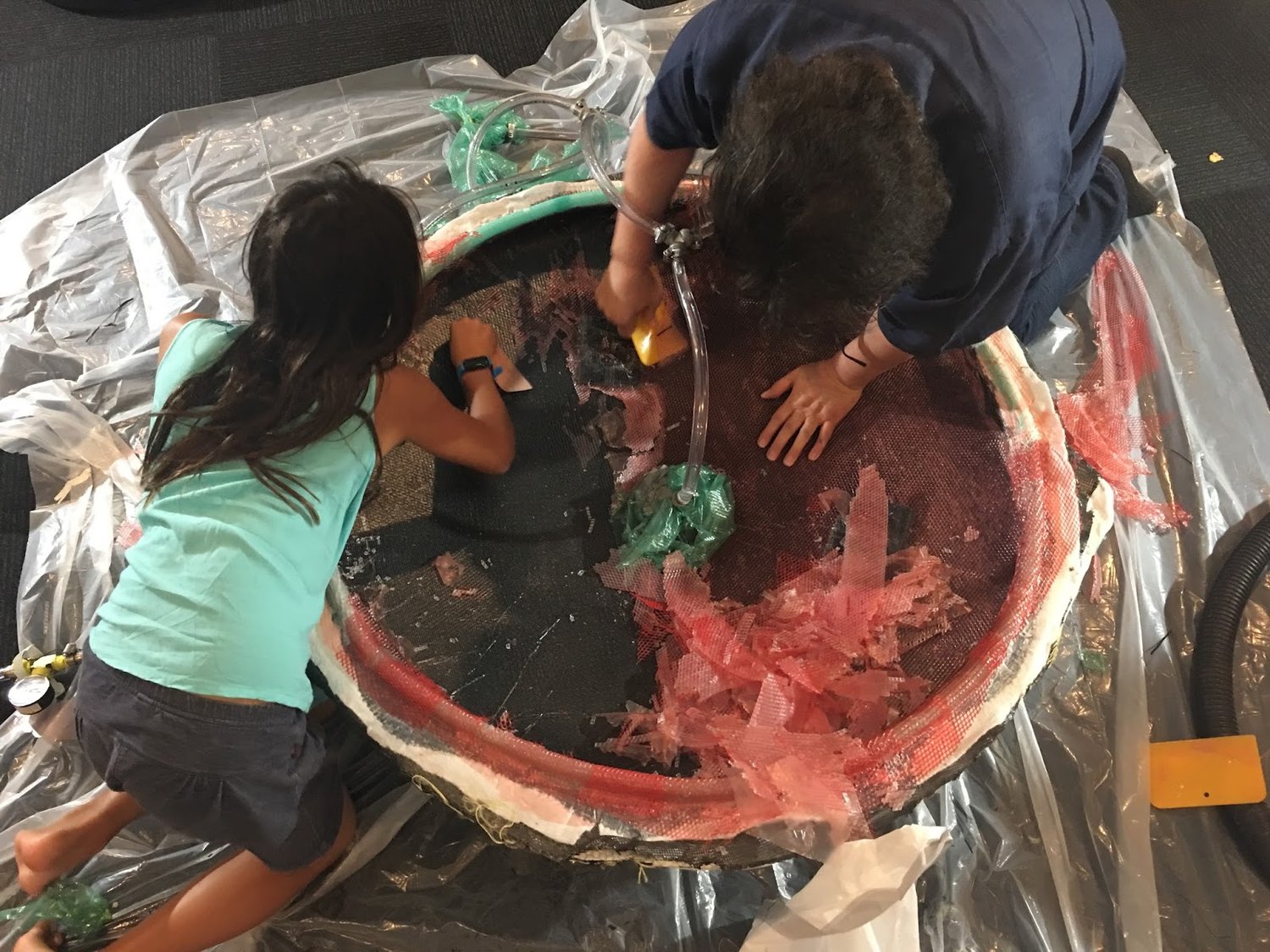 Decanting from the vacuum bag. Chunks of red flow media are visible.